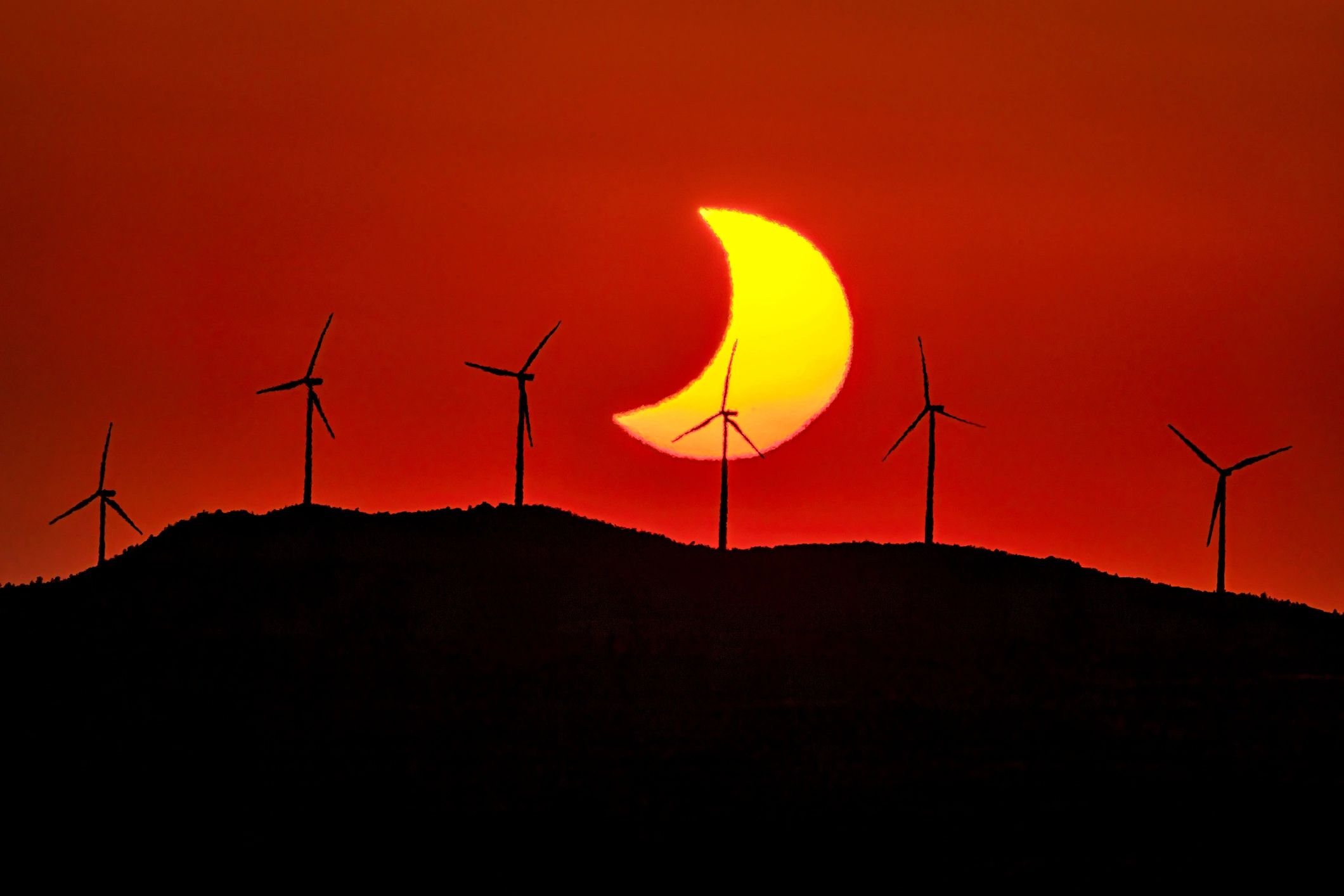 Wind turbines on a hill representing sustainable development